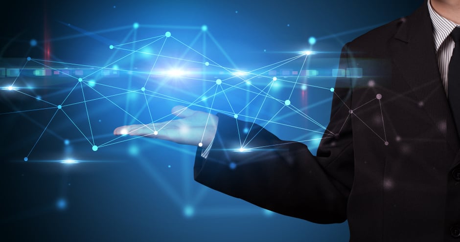 Business professional holding a glowing digital network, symbolizing data integration and cloud technology.