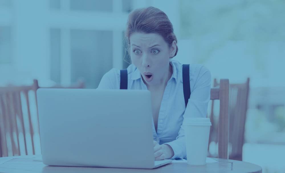 Shocked young business woman using laptop looking at computer screen blown away in stupor sitting outside corporate office. Human face expression, emotion, feeling, perception, body language, reaction